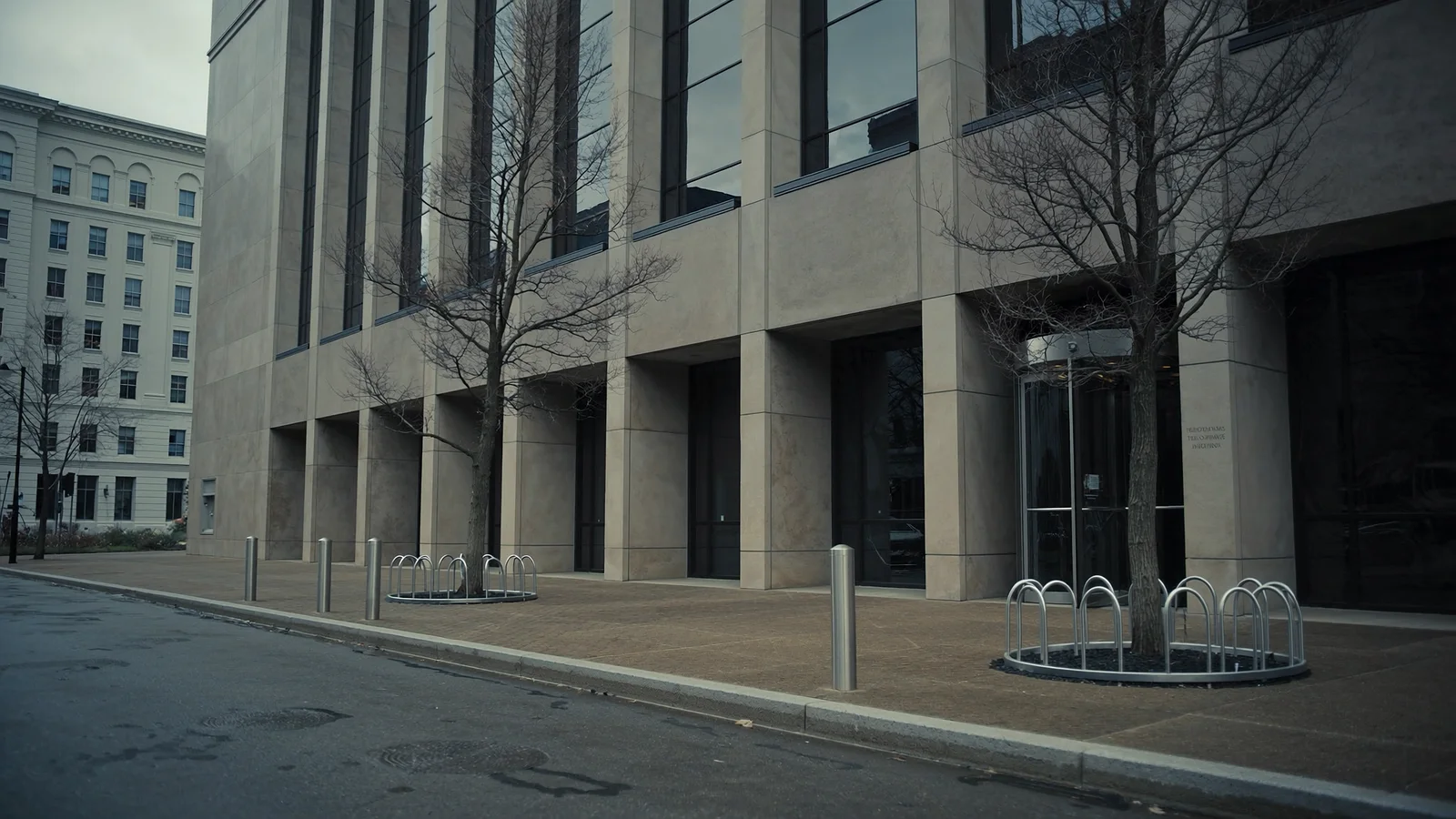 A restrained limestone and glass office building on a wet Washington D.C. street