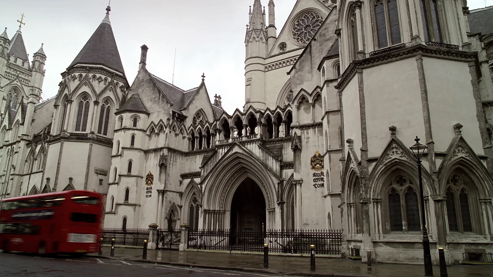 The ornate stone facade of a Victorian Gothic law courts building in London on a wet morning