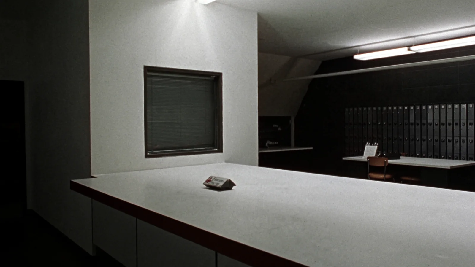 An empty public records counter after hours with a closed service window and a wall of file drawers