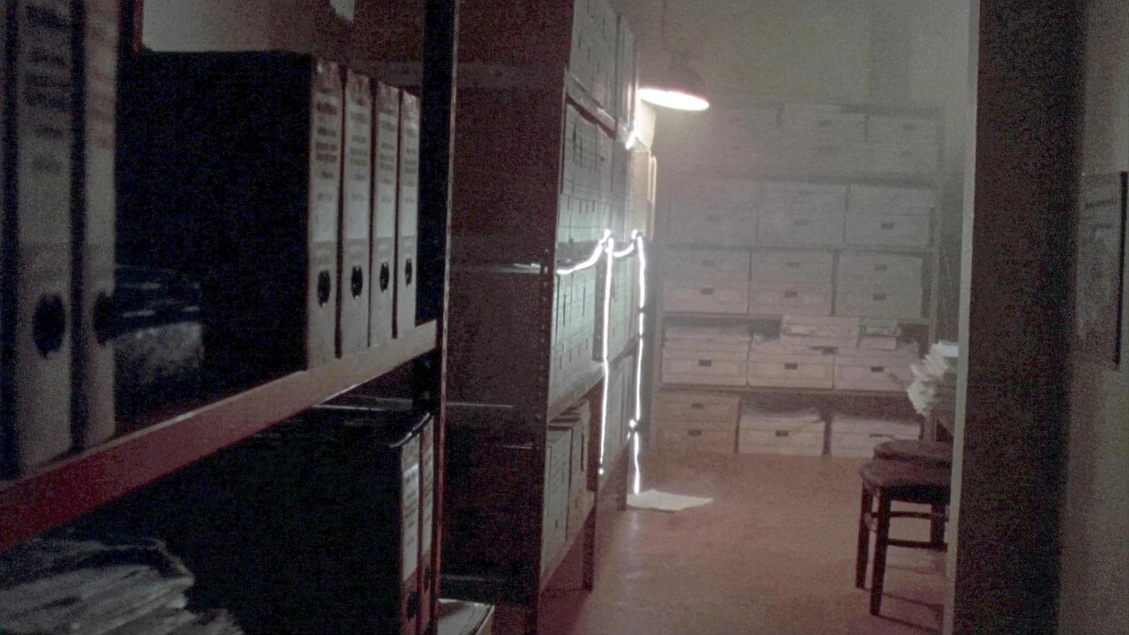 Aisles of metal shelving stacked with hundreds of cardboard case file boxes