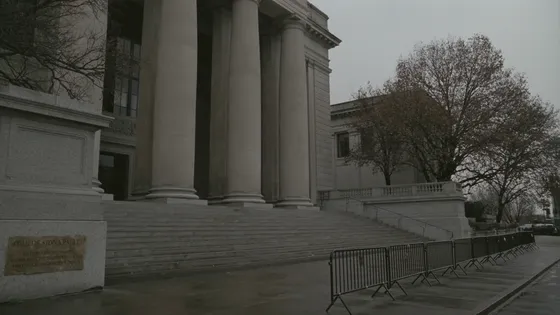 The empty stone steps of a courthouse with press barriers to one side