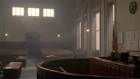 An empty courtroom with vacant public benches and counsel tables